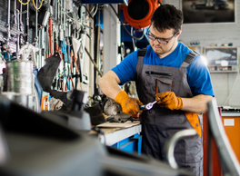 Mechanic in a workshop using a wrench.