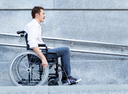 Man in wheelchair next to a ramp