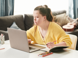 A woman with down syndrome working at her desk at home