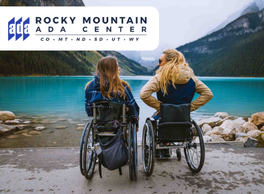 Two woman in wheelchairs on a paved surface at the edge of a large lake between two mountains. Logo: Rocky Mountain ADA Center.